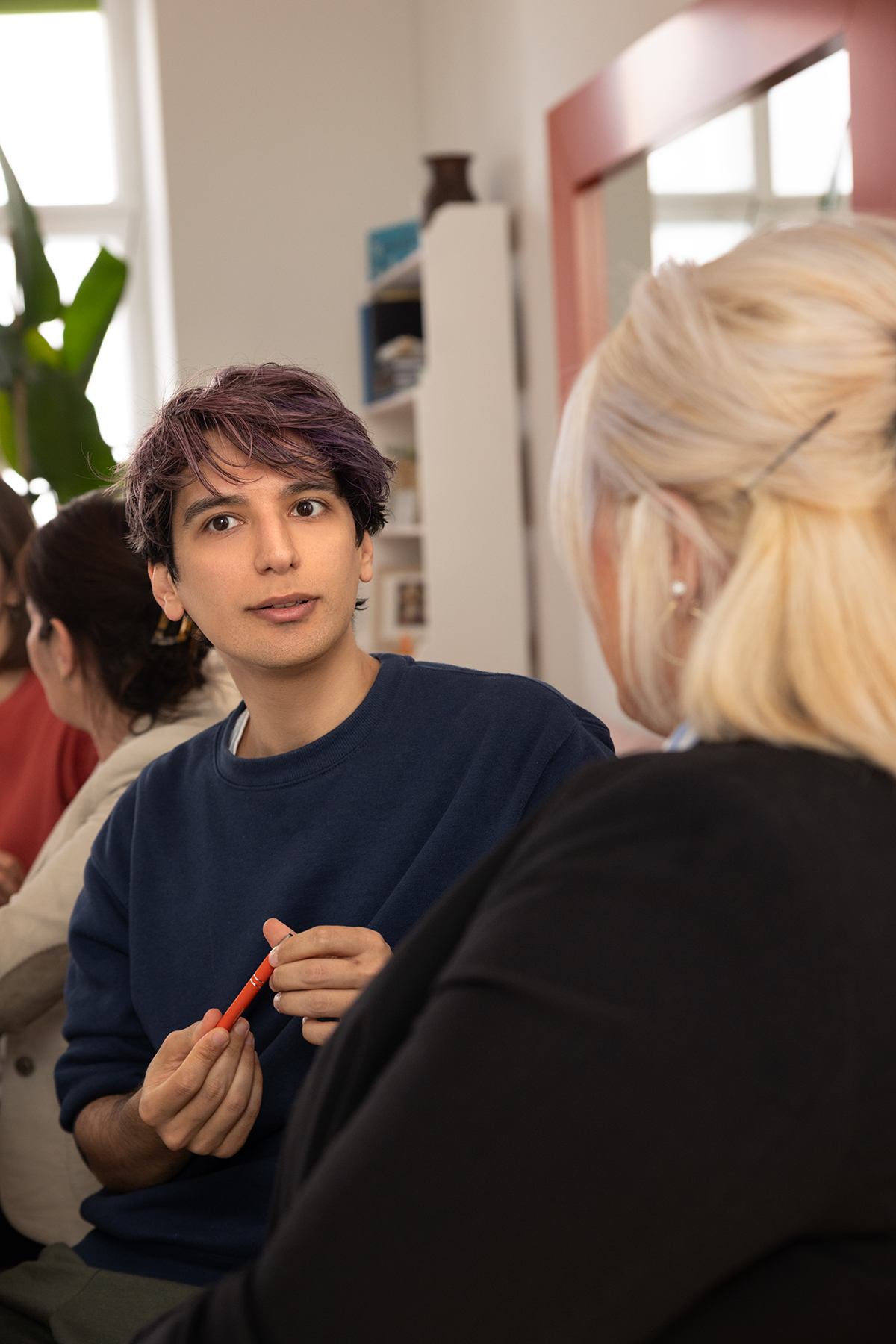 A male workshop participant holding a pen and concentrating.